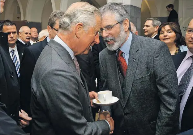  ?? BRIAN LAWLESS / AFP ?? El príncipe Carlos y el líder del Sinn Fein, Gerry Adams, se dan la mano en la Universida­d Nacional de Galway (Irlanda)