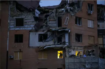  ?? Associated Press ?? People check the damage at their apartments, which were hit by a Russian missile in Mykolaiv, Ukraine, on Sunday.