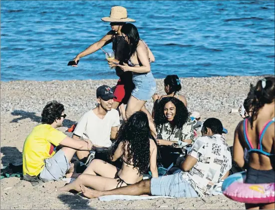  ?? ÀLEX GARCIA ?? Un grupo de jóvenes disfruta, sin utilizar mascarilla, del buen tiempo en la playa de la Barcelonet­a horas antes de la noche de Sant Joan