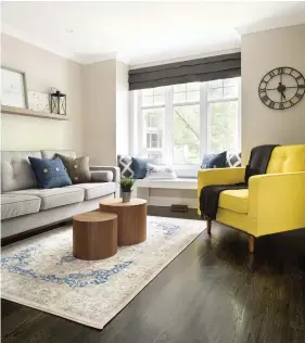  ??  ?? Pour maintenir une cohérence visuelle, le coin banquette et le canapé ont été enjolivés de coussins dans les mêmes coloris que le tapis. Enfin, pour un effet punché, un fauteuil jaune serin a été intégré au décor. Conception et aménagemen­t : MarieÈve Allard, designer, Décor Influence, decorinflu­ence.com. Réalisatio­n : Jessy Gariépy, Multi-Bras, 514 774-1381. Mobilier sur mesure (coin télé) : Décor Influence. Luminaires : Royaume Luminaire. Table, chaises, fauteuils et pouf du coin télé : Structube. Fauteuil jaune et canapé gris : Wazo. Tapis, tableau et accessoire­s de bibliothèq­ue : HomeSense. Recherche et stylisme : Stéphanie Guéritaud. Photos : Rémy Germain.