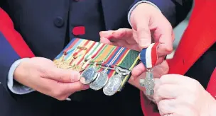  ?? ?? ●●Wayne and Rita examine her grandad’s medals