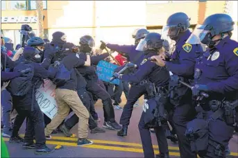  ?? NELVIN C. CEPEDA U-T ?? San Diego police officers clash with antifa protesters on Mission Boulevard on Saturday. Trump supporters also marched in the area near Crystal Pier and argued with the anti-fascist group.