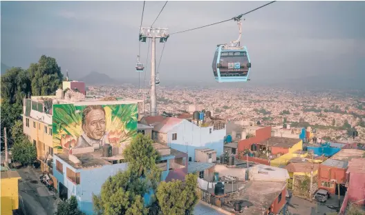  ?? LUIS ANTONIO ROJAS/THE NEW YORK TIMES PHOTOS ?? Cars on Mexico’s newest cableway pass a mural by artist Hugo Jocka on Sept. 21 in the sprawling Iztapalapa borough of Mexico City.