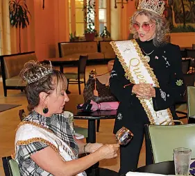  ?? The Sentinel-Record/Tanner Newton ?? Her Royal Highness Beth Gipe Queen Jazz IX, left, is presented with her engraved goblet Wednesday during the annual luncheon of the Hot Spring Jazz Society Royalty by H.R.H. Sharon Turrentine QJII in the lobby of the Arlington Resort Hotel & Spa.