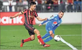  ?? AP-John Amis ?? Atlanta United’s Pity Martinez, left, knocks the ball in for a goal as Motagua’s Omar Elvir defends during the second half of CONCACAF Champions League soccer match on Tuesday in Kennesaw.