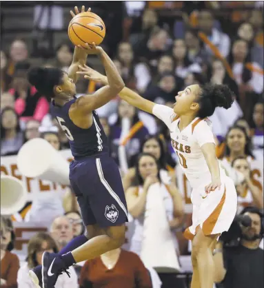  ?? Eric Gay / Associated Press ?? UConn guard Crystal Dangerfiel­d, left, shoots over Texas guard Brooke McCarty during the first half of Monday night’s game in Austin, Texas.