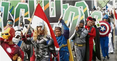  ??  ?? Powerful statement: Indonesian­s dressed in superhero costumes marching during a ceremony in Jakarta to the kick off the campaign period for next year’s election. — AP