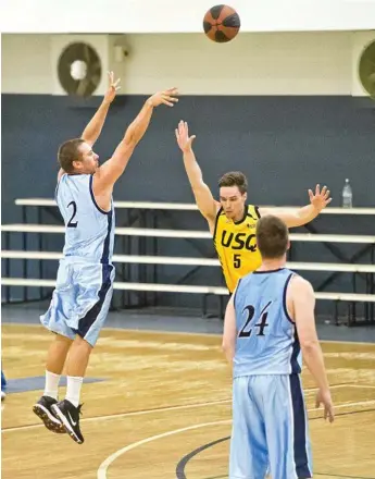  ?? Photos: Nev Madsen ?? FROM DOWNTOWN: Jason Ebneter of the Toowoomba Saints puts up a three-ball under pressure from USQ guard Joe McConnell.