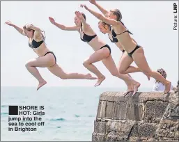  ??  ?? SHORE IS HOT: Girls jump into the sea to cool off in Brighton