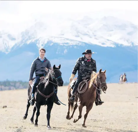  ?? JONATHAN HAYWARD/THE CANADIAN PRESS ?? Prime Minister Justin Trudeau rides a horse alongside Chief Joe Alphonse, along with several other chiefs of the Tsilhqot’in National Government, on Friday, in honour of those chiefs who rode horses in 1864 to what they believed were peace talks.