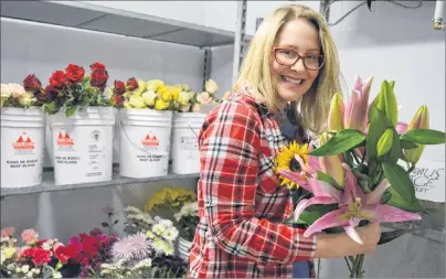  ?? NIKKI SULLIVAN/CAPE BRETON POST ?? Katie Hodder holds a bunch of her favourite flowers, lilies, in the flower fridge at her new shop, Family HeirBlooms Flowers, Gifts and Décor in New Waterford.