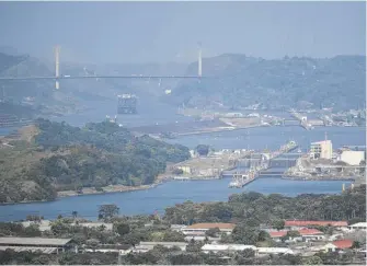  ?? AGUSTIN HERRERA/AP ?? A cargo ship waits near the Centennial Bridge for transit through the Panama Canal locks in Panama City last Wednesday.