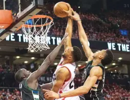  ?? (Reuters) ?? TORONTO RAPTORS guard Norman Powell dunks over Milwaukee Bucks defenders Giannis Antetokoun­mpo (right) and Thon Maker for two of his team-high 25 points in the Raptors’ 118-93 home conquest of the Bucks in Monday night’s Game 5 of the Eastern...