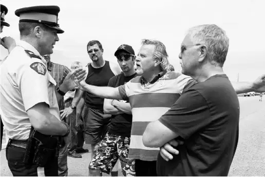  ?? LORRAINE HJALTE / POSTMEDIA NEWS ?? Evacuees confronted the RCMP on Thursday in a bid to re-enter High River, one week after the river flooded the town.