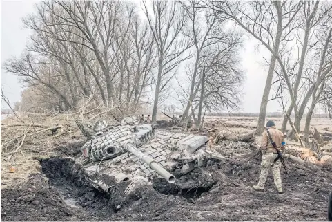  ?? NYT ?? A Ukrainian soldier looks over the wreck of a Russian tank that became stuck in the mud near the village of Zavorychi, Ukraine on April 5.