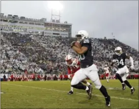  ?? CHRIS KNIGHT — THE ASSOCIATED PRESS ?? Penn State’s Saquon Barkley (26) takes the ball 65yards for a touchdown against Nebraska during the first half of a Saturday’s game in State College, Pa. Penn State won 56-44.