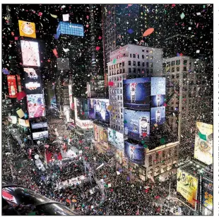  ?? AP/SETH WENIG ?? Confetti drops over the crowd as the clock strikes midnight during the New Year’s celebratio­n at Times Square in New York City.