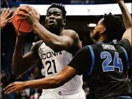  ?? Jessica Hill /Associated Press ?? UConn's Adama Sanogo is guarded by Buffalo's Jonnivius Smith in the first half of an NCAA college basketball game on Tuesday in Hartford.