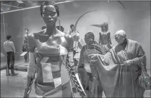  ?? The Washington Post/BILL O’LEARY ?? Guests examine a mannequin adorned in a leather patchwork evening gown by L’Amour Ameer at the launch of “Inspiring Beauty: 50 Years of Ebony Fashion Fair” exhibition March 31 in Washington.