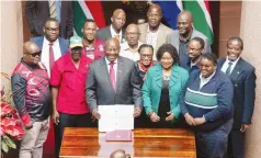  ?? ?? South Africa’s President Cyril Ramaphosa, flanked by Minister of Health, Dr Joe Phaahla and other stake holders, pose for a group photo at the Union Buildings, after signing the National Health Insurance Bill into law in Pretoria yesterday