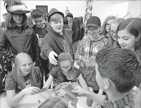  ?? [SHANNON GILCHRIST/DISPATCH] ?? Students at Jackson Middle School in the South-Western district will be writing the endings to short stories started by profession­al authors. The idea, called the Young Adult Authors Unfinished StoryBox, was unveiled to students on Friday, when they...