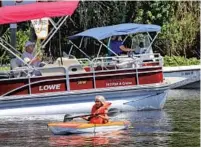  ?? JOE BURBANK/ORLANDO SENTINEL ?? Boaters congregate at the site where a dead manatee was spotted near Hontoon Island State Park near DeLand on Monday. The park on the St. Johns River is one of 80 that have reopened across Florida.