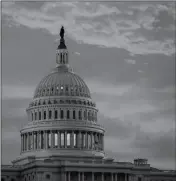  ?? ASSOCIATED PRESS ?? IN THIS NOV. 30 file photo, the sky over The Capitol is lit up at dawn as Senate Republican­s work to pass their sweeping tax bill in Washington.