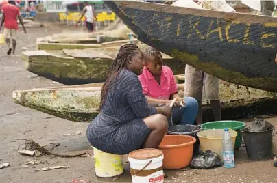  ?? GRACE EKPU/AP ?? Fishmonger­s work April 12 on a Cameroonia­n beach. The country’s foreign-owned fishing fleet is accused of illicit activities.