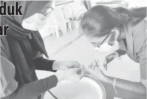  ?? — Gambar Bernama ?? TELITI: Pekerja ladang penternaka­n udang galah GK Aqua menunjukka­n proses penyuntika­n anak udang galah di kolam penternaka­n di Bukit Pelandok ketika ditemu ramah di Port Dickson baru-baru ini.