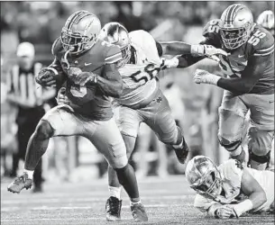  ?? David Dermer Associated Press ?? OHIO STATE running back Miyan Williams, left, eludes Notre Dame defenders Howard Cross III, second from left, and JD Bertrand, bottom, during the fourth quarter.