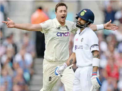  ?? AFP ?? England’s Ollie Robinson after taking the wicket of India’s captain Virat Kohli, right, for 50 runs during first day play Thursday in the fourth Test match between England and India.