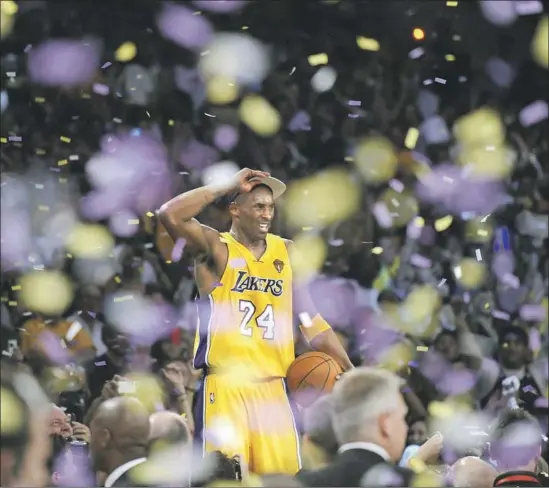  ?? Wally Skalij Los Angeles Times ?? KOBE BRYANT stands on the scorer’s table to take in the celebratio­n of the Lakers’ 2010 title, clinched in an excruciati­ngly tense Game 7 win over the Boston Celtics.