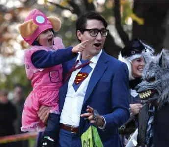  ?? JUSTIN TANG/THE CANADIAN PRESS ?? Prime Minister Justin Trudeau, as DC Comics character Clark Kent, goes trick-or-treating with his son Hadrien.