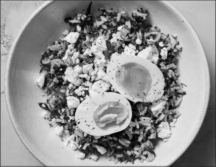  ?? CHRISTOPHE­R TESTANI / THE NEW YORK TIMES ?? Hetty Lui Mckinnon’s take on the Greek spinach rice dish spanakoriz­o includes a nontraditi­onal jammy egg — a pleasant, sunny burst of yolk amid the green.