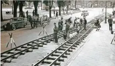  ??  ?? 5. Juli 1947: Beim Königsplat­z (links) werden Feldbahnsc­hienen auf der Schaezler straße verlegt. Darauf fuhr die Trümmerbah­n zum Rosenauhan­g.