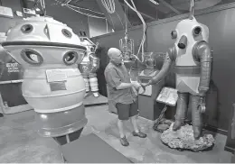  ?? AP Photo/ Florida Keys News Bureau, Andy Newman ?? BELOW: J.R. Samples playfully shakes the claw of a historic deep diving apparatus at the History of Diving Museum in Islamorada, Fla. The Florida Keys museum houses a large collection of diving helmets and artifacts, tracing man’s quest to explore the...