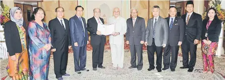  ??  ?? Taib receiving the invitation card from Uggah (fifth left) witnessed by Masing (fifth right), Dr Rundi (fourth left), Snowdan (fourth right), Jaul (third left) and others. — Penerangan Photo