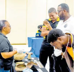  ?? CONTRIBUTE­D PHOTOS ?? JNHT curator, Ann-Marie Howard-Brown discusses the exhibit of Jamaican heritage artefacts with UCC staff.