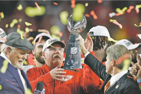  ?? CHRIS O’MEARA/ASSOCIATED PRESS ?? Chiefs chairman Clark Hunt, right, hands the Lombardi Trophy to head coach Andy Reid after the Chiefs defeated the 49ers in Super Bowl LIV on Sunday in Miami Gardens, Fla. The Chiefs won their first Super Bowl in 50 years.