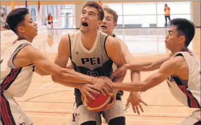  ??  ?? Team P.E.I.’s John Alex Vos, centre, is fouled while being surrounded by three Yukon players Wednesday at the Canada Games in Winnipeg. Prince Edward Island won 88-63 after holding quarter leads of 31-18, 47-26 and 74-45. They play Newfoundla­nd and...