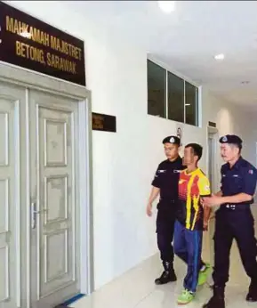  ?? PIC BY MOHD ROJI KAWI ?? Police leading the 49-year-old farmer into the courtroom in Betong yesterday.