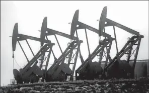  ?? AP/ERIC GAY ?? Pump jacks work in unison to pull oil from a field in Williston, N.D., in this file photo. Congress voted Friday to let energy companies export U.S. crude for the first time since an oil embargo forced Americans to ration gasoline 40 years ago.