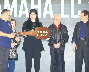  ??  ?? Raghad (third right) presents a mock key to a lucky draw winner. Seen from right are Abang Johari, Taib and Juma’ani.