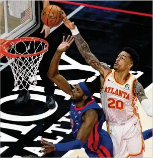  ?? JOHN BAZEMORE/ASSOCIATED PRESS ?? Hawks forward John Collins (right) blocks a shot by Pistons forward Jerami Grant with less than a second remaining in regulation Wednesday night, forcing overtime.