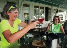  ?? Timothy Wright / Washington Post ?? DeAnn Tierney of Richmond splits a post-ride glass of wine at the winery and restaurant at Shirley Plantation in Charles City County, Va.