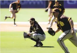  ?? GREGORY BULL AP ?? Padres starting pitcher Chris Paddack (center) won’t have to hit or run the bases under new rules that were adopted for the shortened COVID-19 campaign.