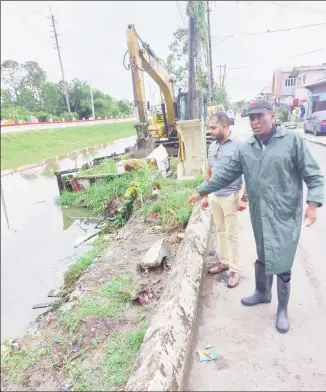  ?? ?? Deputy Mayor of Georgetown, Alfred Mentore (front) and Region Four Chairman, Daniel Seeram overseeing work to have the drainage canal cleared