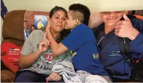  ?? PAUL W. GILLESPIE/BALTIMORE SUN MEDIA GROUP ?? Jarren Jasper kisses his mother, Donna. Jarren, the son of Navy offensive coordinato­r Ivin Jasper, was fighting for his life this time last year after a relatively low-risk procedure.