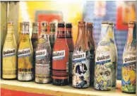  ??  ?? ARRIBA, un pintoresco rincón de la pizzeria. Sobre estas líneas, botellas de cervezas Quilmes, una marca de cerveza argentina que produce esta bebida desde el siglo XIX.