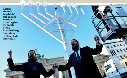  ?? PHOTO: GETTY IMAGES ?? Rabbis Shmuel Segal (left) and Yehuda Teichtal unveil a giant menorah by the Brandenbur­g Gate ahead of Chanukah last Friday